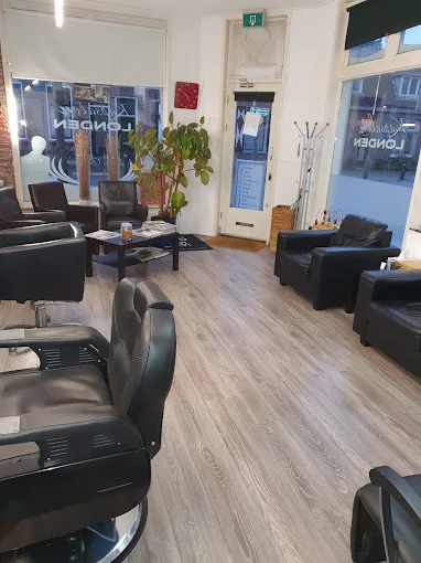 Het interieur van Kapsalon Londen met zwart-leren stoelen en een lichte houten vloer